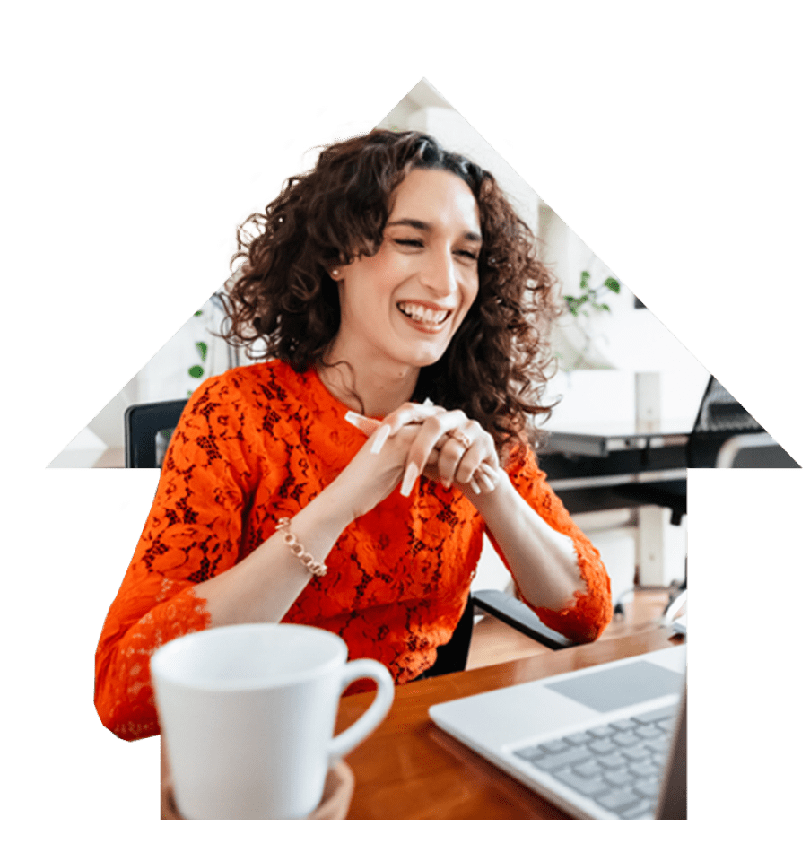 Smiling woman sitting at her desk working on her laptop