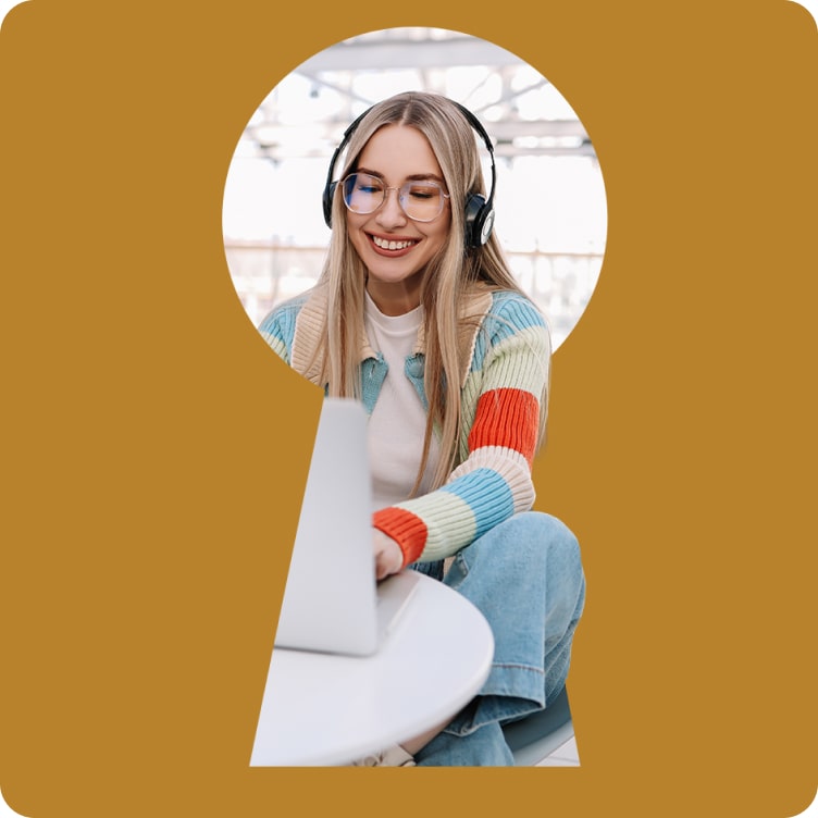 Smiling woman wearing headphones working at her computer in a casual setting