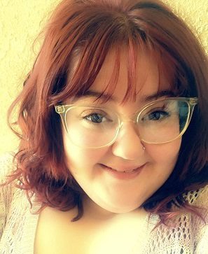 A photo of a woman with brown hair, glasses, and a smile.