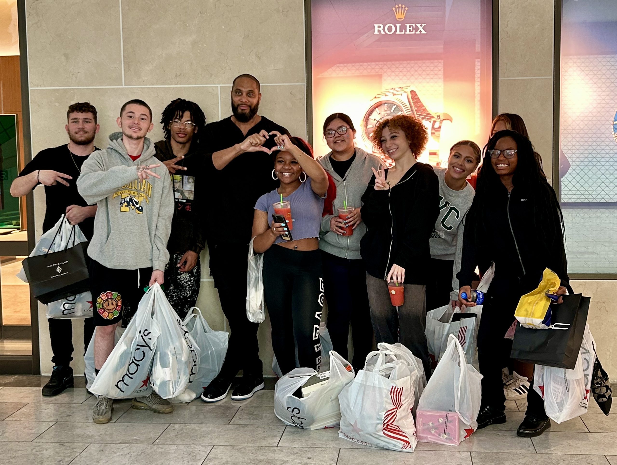 A group of teens with shopping bags smiling
